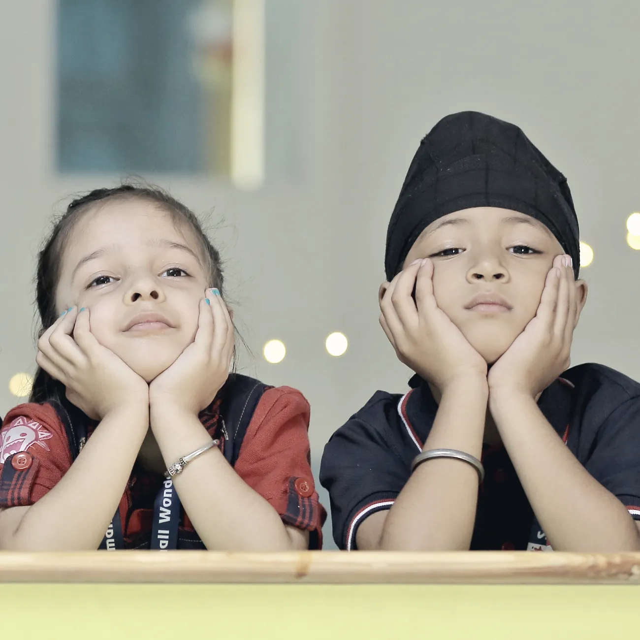 Four learners resting their chins on their hands at a low table, waiting for a story.