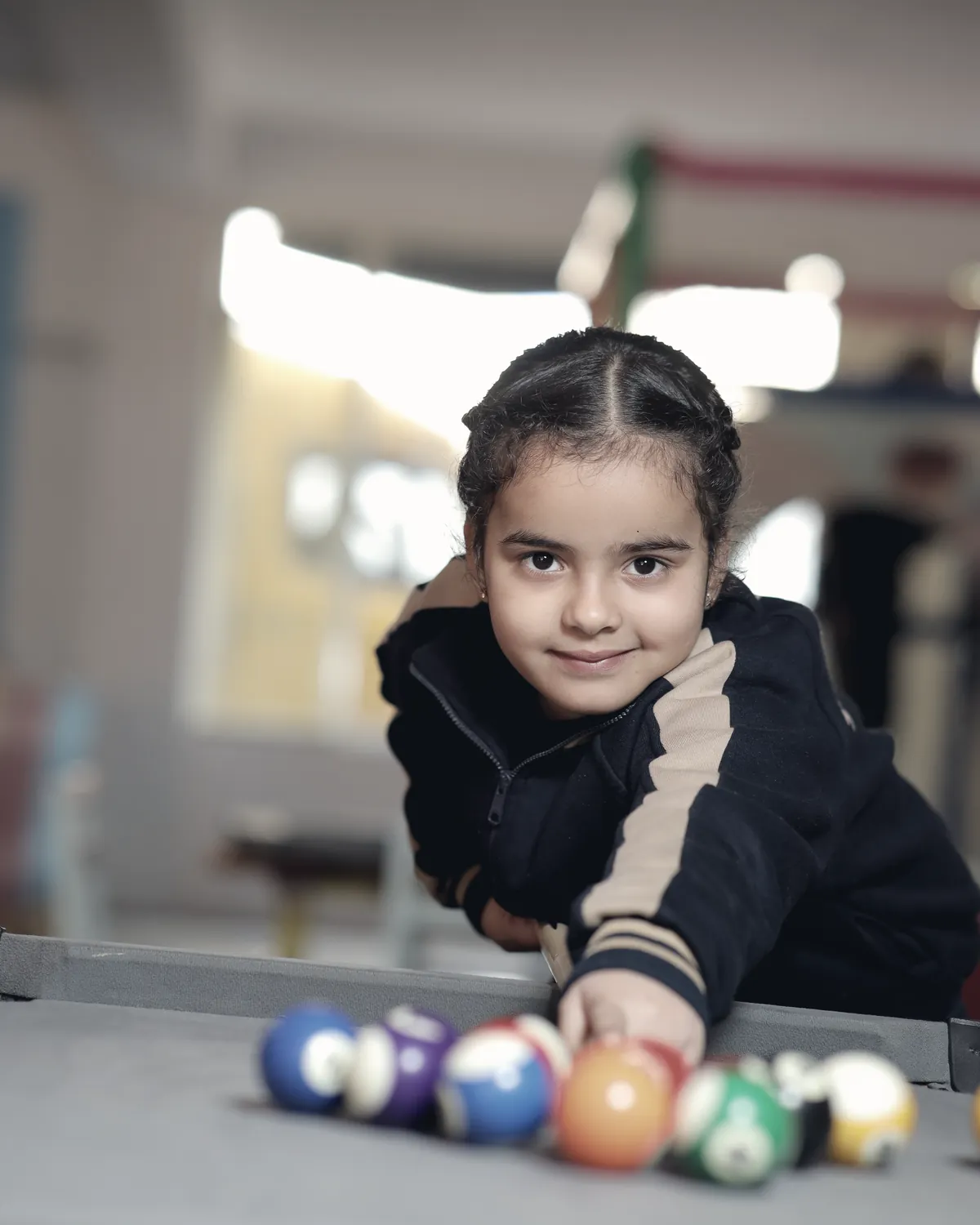 A learner leaning over the games table, lining up the next shot.